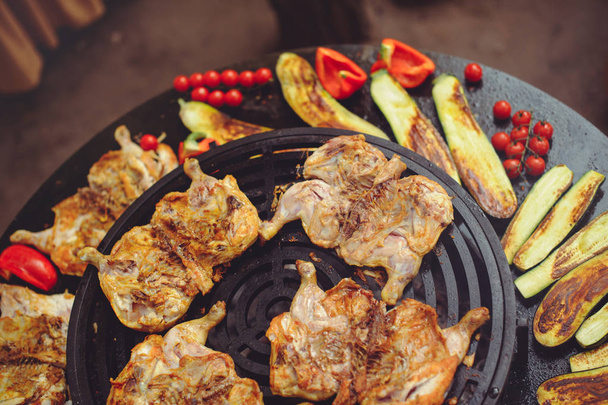 Ο σεφ μαγειρεύει κρέας στη σχάρα. Χρυσά παϊδάκια και κοτόπουλο με ψητά λαχανικά, νόστιμο φαγητό - Φωτογραφία, εικόνα