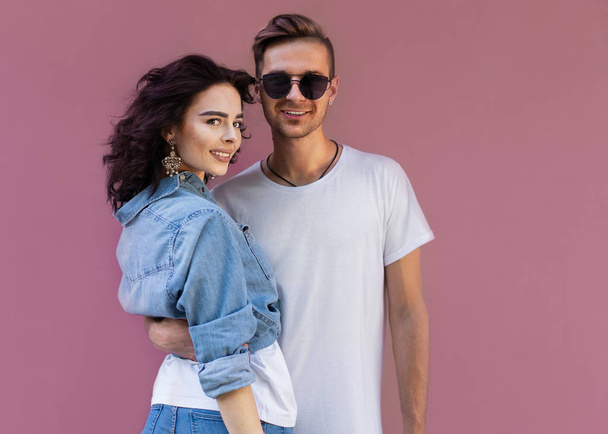 fashion couple in sunglasses posing on pink wall - Foto, Imagem