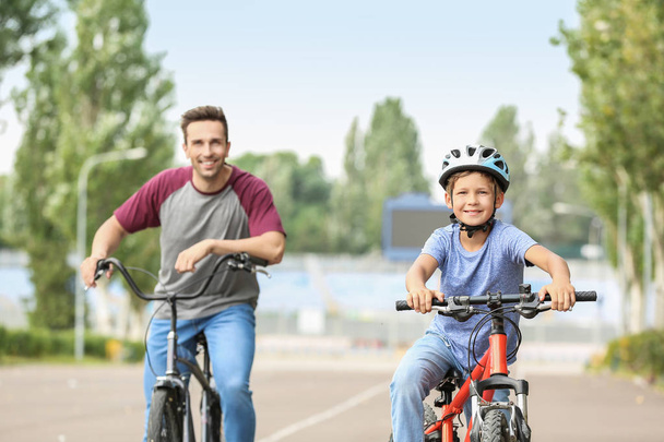 Szczęśliwy ojciec i syn jazda konna rowery na dworze - Zdjęcie, obraz