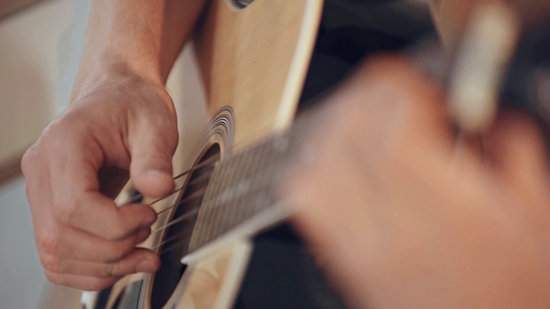 częściowy widok człowieka gra gitara akustyczna w domu - Materiał filmowy, wideo