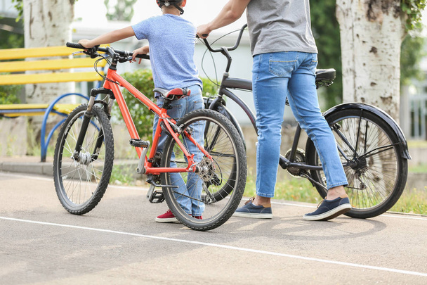 Happy father and son riding bicycles outdoors - Foto, Bild