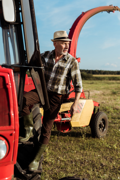 a vezető mezőgazdasági termelő szelektív fókusza a modern traktorra  - Fotó, kép
