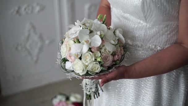Nevěsta drží krásnou kytici bílých růží a orchidejí - Záběry, video