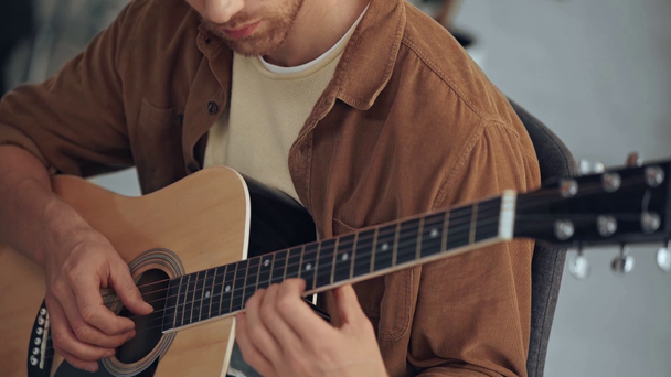 visão parcial do jovem tocando guitarra acústica em casa
 - Filmagem, Vídeo