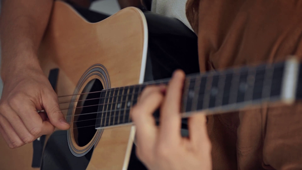 rack focus del hombre tocando la guitarra acústica en casa
 - Imágenes, Vídeo