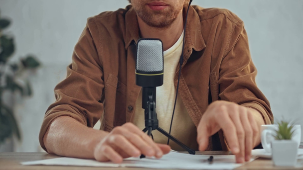 cropped view of man broadcasting with microphone in office - Footage, Video