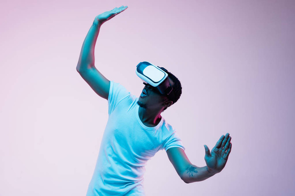 Young african-american mans using VR-glasses in neon light - Fotografie, Obrázek
