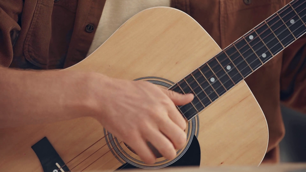cropped view of young man playing acoustic guitar - Filmagem, Vídeo