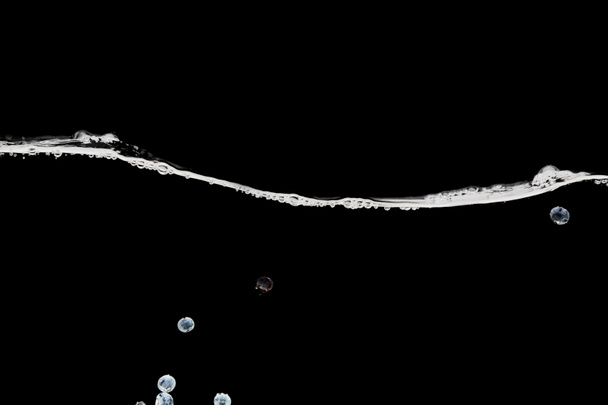 arándanos maduros profundos en agua ondulada aislada en negro
 - Foto, Imagen