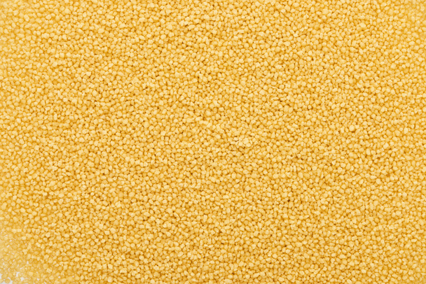 Top zicht op ongekookte biologische couscous grutten - Foto, afbeelding