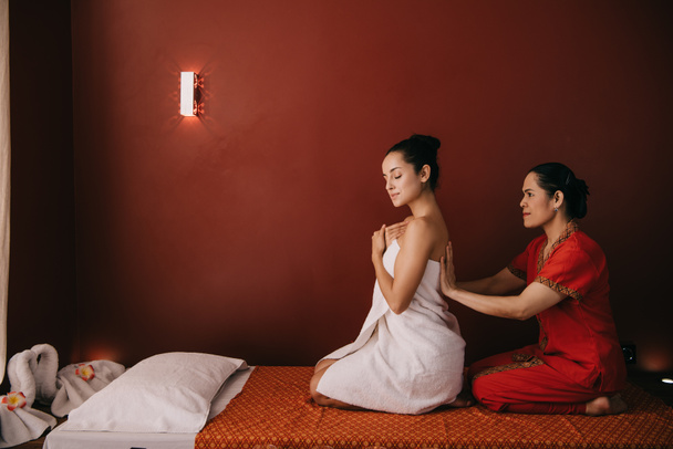 azjatycki masażysta zawijania z ręcznikiem atrakcyjna kobieta w salonie Spa  - Zdjęcie, obraz