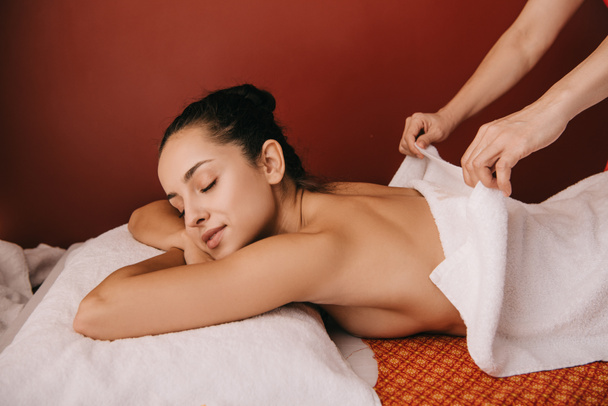 masseur opstijgen handdoek van aantrekkelijke vrouw in Spa Salon  - Foto, afbeelding