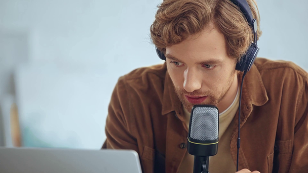 hombre en auriculares con micrófono de radiodifusión y el uso de portátil
 - Metraje, vídeo