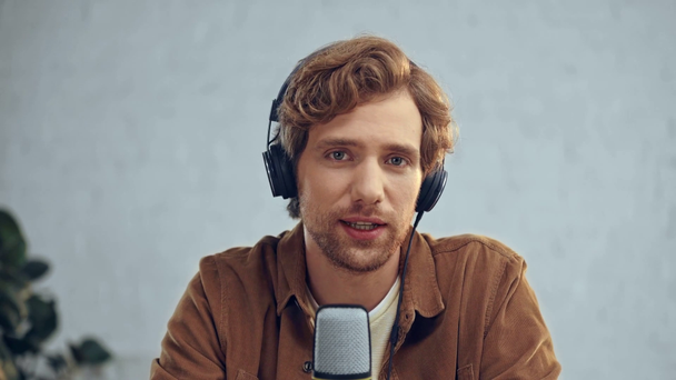 Mann mit Kopfhörer sendet in Mikrofon  - Filmmaterial, Video
