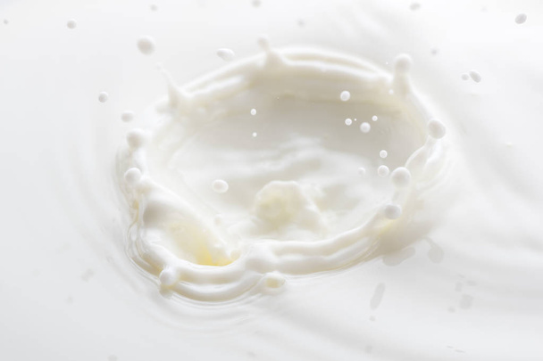 splash from falling drops of white milk on a white background - Foto, Imagem
