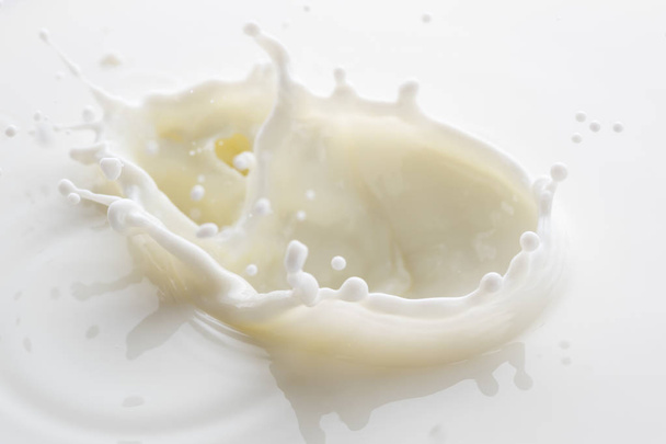 splash from falling drops of white milk on a white background - Foto, Imagen