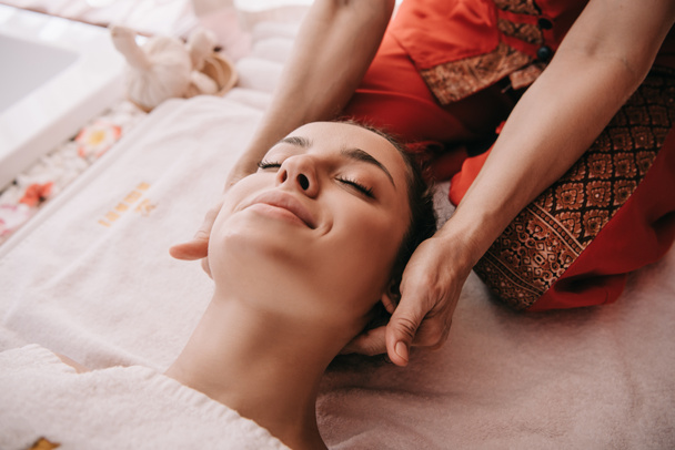 обрезанный вид массажера, делающего массаж шеи женщине в спа-салоне
  - Фото, изображение