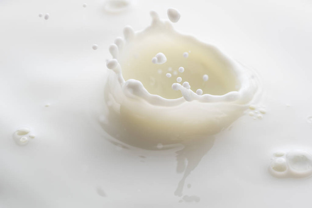 splash from falling drops of white milk on a white background - Foto, imagen