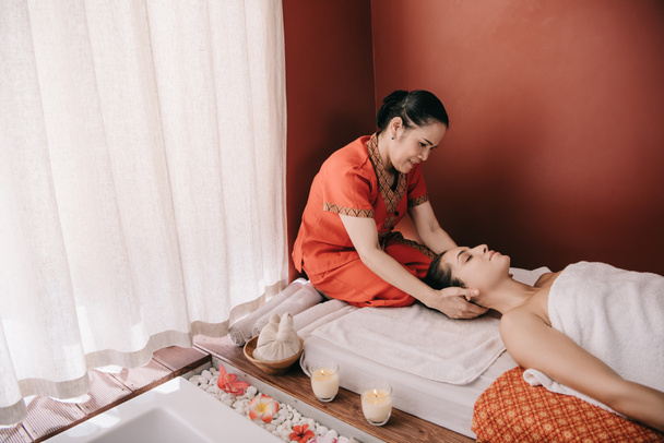 asian masseur doing neck massage to woman in spa salon  - Photo, image
