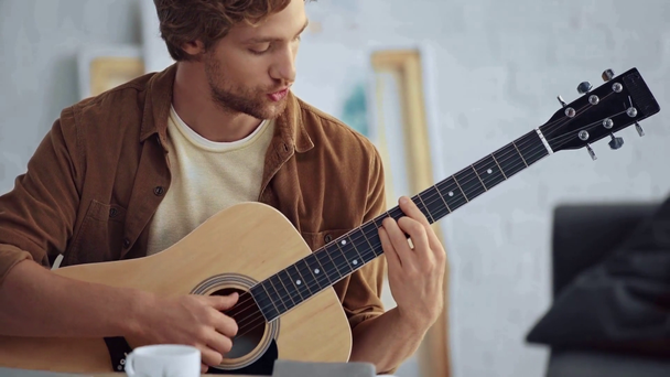 homem tocando guitarra acústica e cantando enquanto olha para a tela do laptop
 - Filmagem, Vídeo