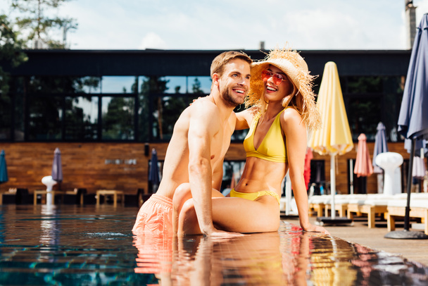 sexy happy couple embracing in swimming pool in sunny day - Photo, Image