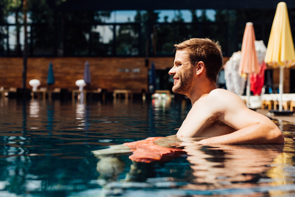 happy shirtless young man in swimming pool in sunny day - Φωτογραφία, εικόνα