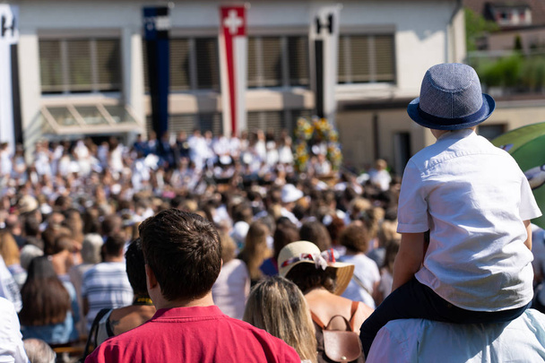 Jugendfest Brugg 2019'da 4 Temmuz'da okul çocuklarının şarkı söylemesini dinleyen izleyiciler ve küçük çocuk. - Fotoğraf, Görsel