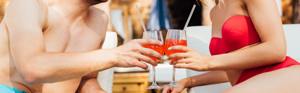 panoramic shot of sexy couple clinking glasses of cocktails - Фото, изображение