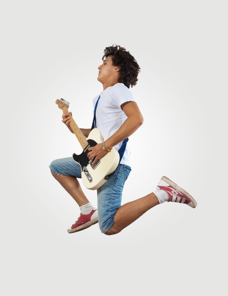 young man playing on electro guitar and jumping - Foto, immagini