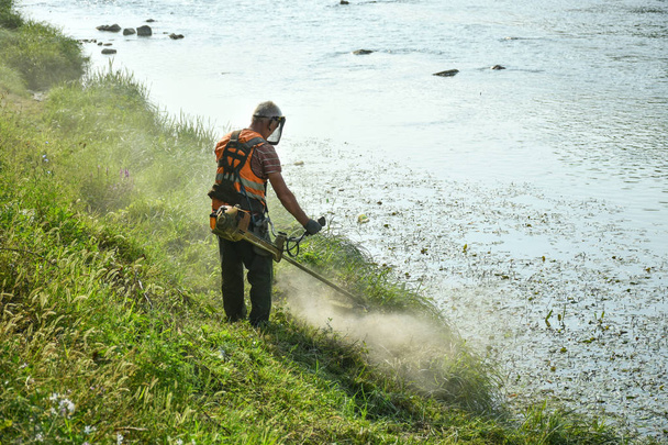 Jardinier tondre l'herbe avec une tondeuse à gazon
 - Photo, image