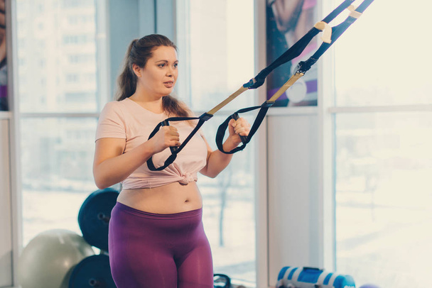 Obese woman goes in for sports in gym, concept of weight loss - Fotografie, Obrázek