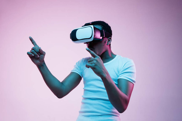 Young african-american mans using VR-glasses in neon light - Valokuva, kuva