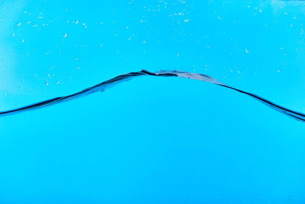 wavy clear fresh water on blue background with drops - 写真・画像