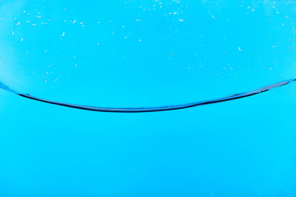 wavy clear fresh water on blue background with droplets - Φωτογραφία, εικόνα