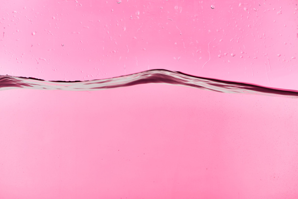 wavy clear fresh water on pink background with drops - Foto, Imagen