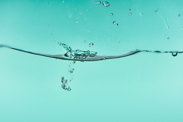 wavy transparent water on turquoise background with splash and bubbles - Foto, Imagem