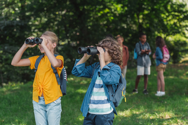 selective focus of happy kids looking through binoculars  - Photo, image