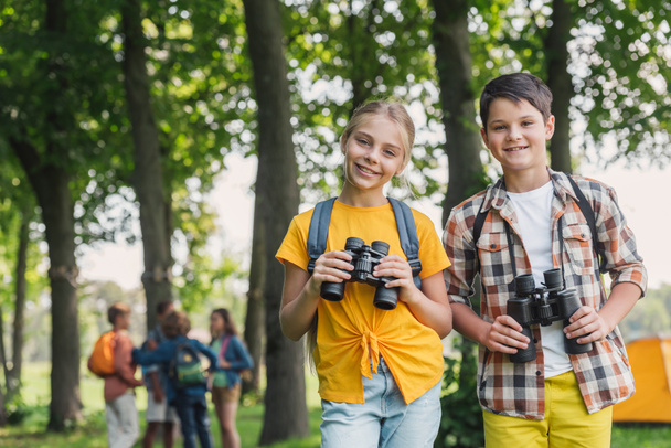 selective focus of happy kids holding binoculars  - Fotó, kép