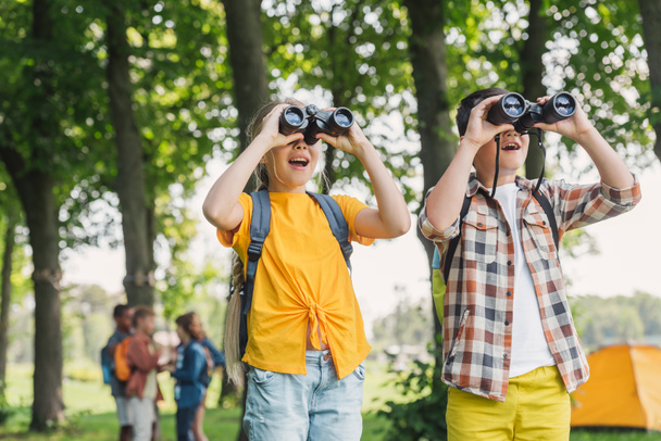 selective focus of happy kids looking through binoculars  - Photo, Image