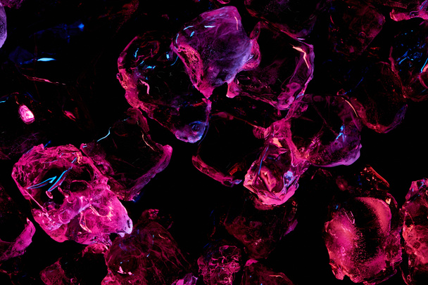 Ansicht von transparenten Eiswürfeln mit lila Beleuchtung isoliert auf schwarz - Foto, Bild