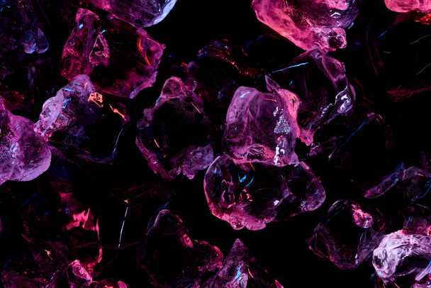 top view of transparent ice cubes with purple lighting isolated on black - Foto, Imagem