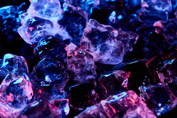átlátszó jégkockát lila fény izolált fekete - Fotó, kép