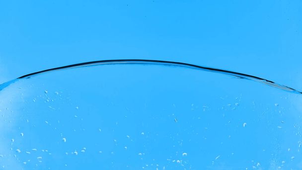 agua transparente ondulada sobre fondo azul con gotitas
 - Foto, Imagen
