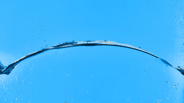 wavy transparent water on blue background with droplets - Fotó, kép