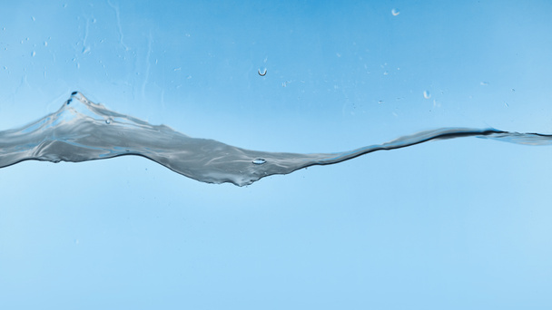 wavy transparent water on blue background with droplets - Fotografie, Obrázek