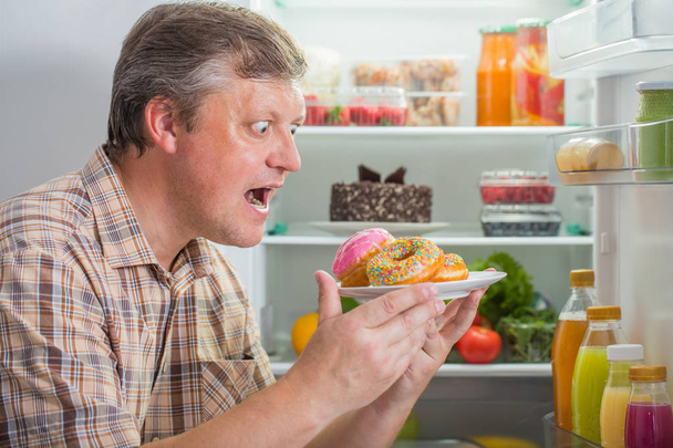 mature men at fridge  with food - Fotografie, Obrázek