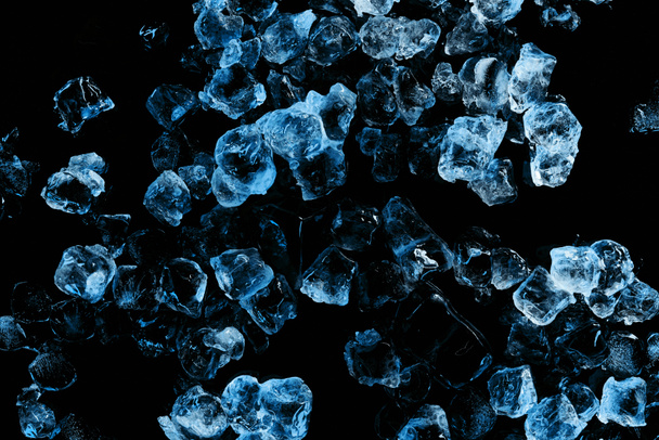 top view of frozen ice cubes with blue illumination isolated on black - Foto, Imagen