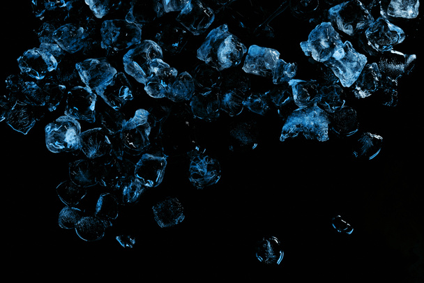 vista superior de cubitos de hielo congelados con luz azul aislada en negro
 - Foto, imagen