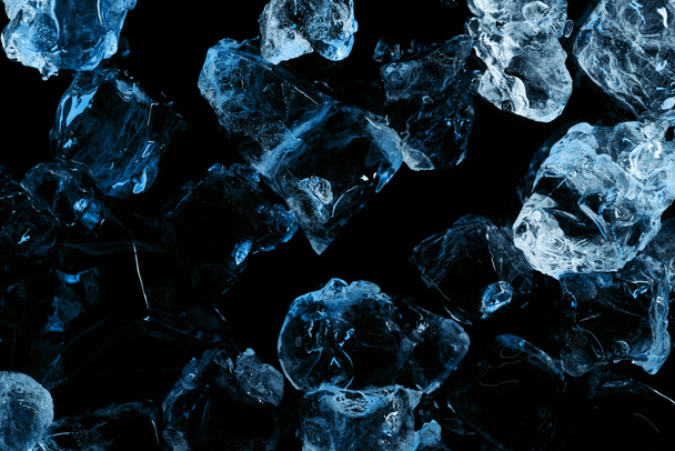 top view of frozen ice cubes with blue light isolated on black - Foto, afbeelding