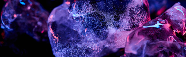 Panoramaaufnahme transparenter Eiswürfel mit lila, farbenfroher Beleuchtung isoliert auf schwarz - Foto, Bild